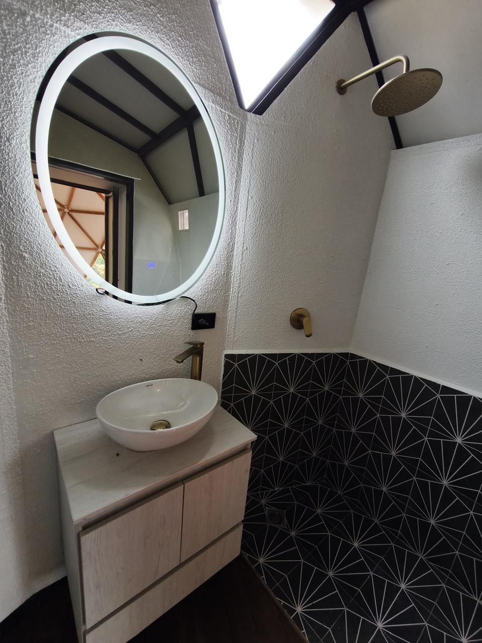 The completed bathroom vanity, mirror, and rainfall shower