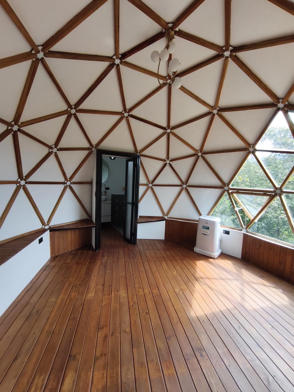 The dome interior with wood floors and mountain-facing windows