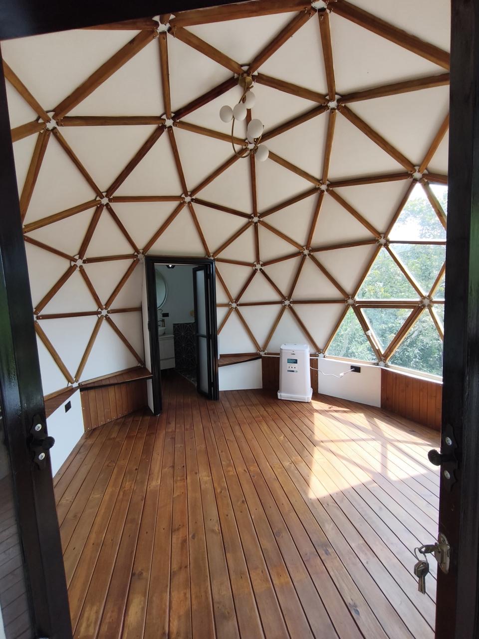 The open unfurnished dome interior with geometric wood beams